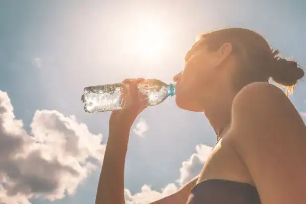 Hydration: The Secret Ingredient for a Toned Stomach and Enhanced Fitness 3 Image of woman drinking water to hydrate Brentford after run.