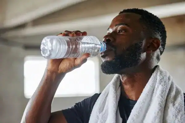 Hydration: The Secret Ingredient for a Toned Stomach and Enhanced Fitness 1 Image of man drinking water to improve hydration Brentford after work out.